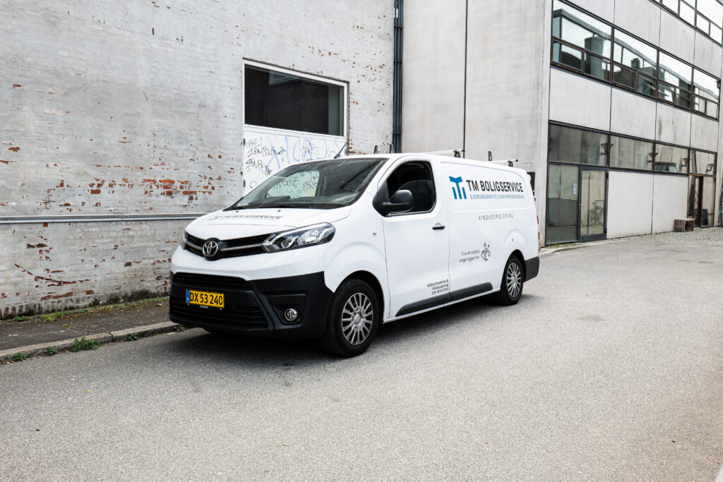 TM Boligservices servicebil ved en erhvervsejendom